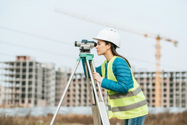 Side view of Surveyor measuring land with digital level